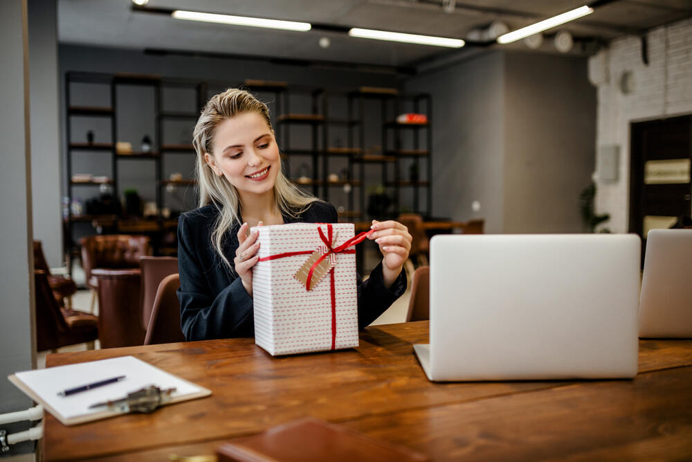 An employee opens up an appreciation gift from her employer 