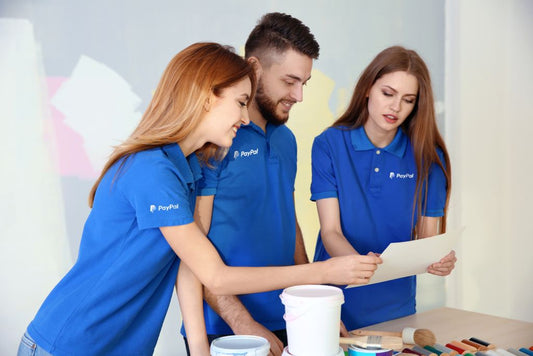 Employees in blue uniforms discuss business plans.