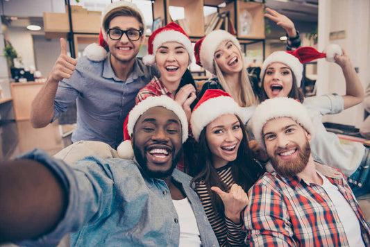 Employees take a group selfie at their office Christmas party 